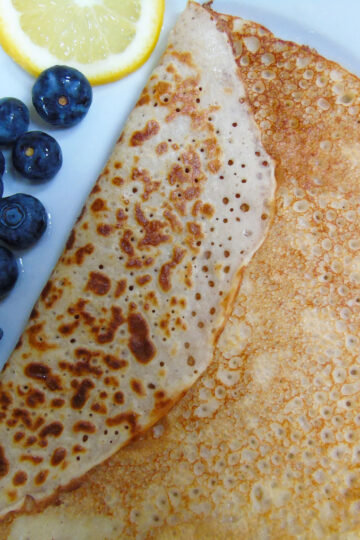 Pancake on a plate with blueberries and lemon