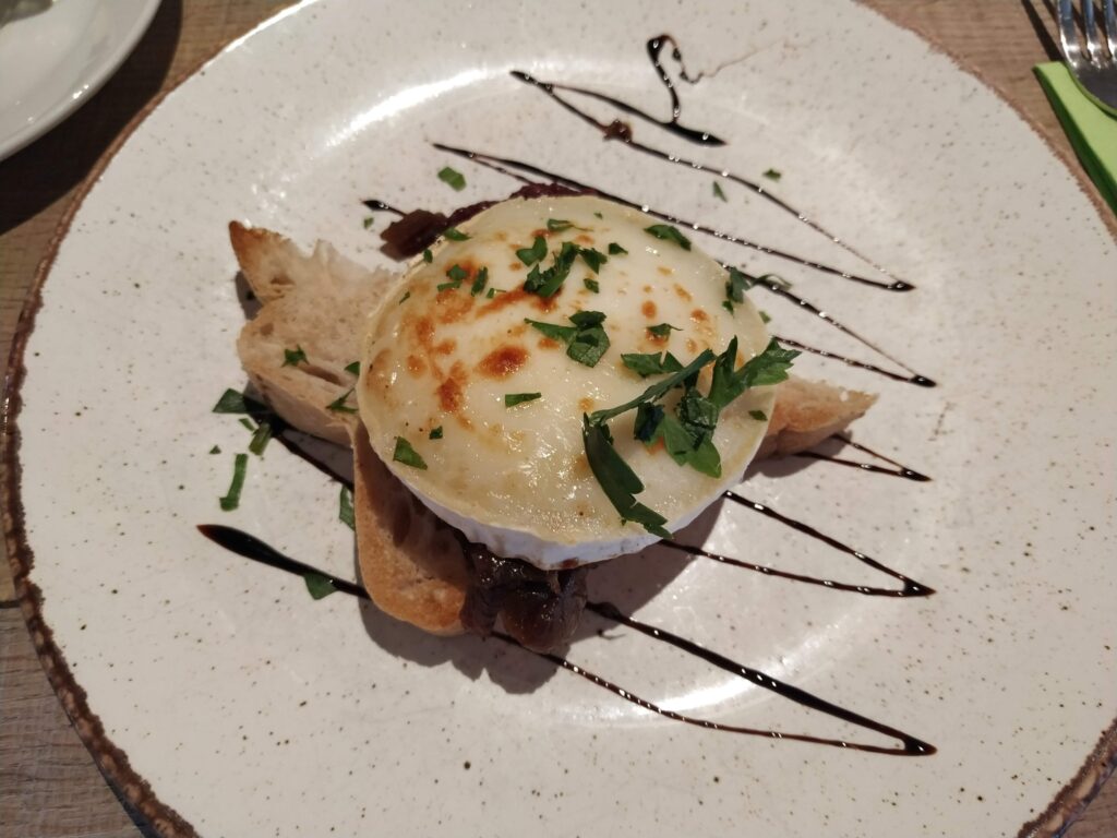 Grilled goat's cheese and caramelised onion on gluten free bread as starter, served on a plate