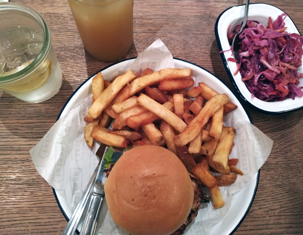 Honest Burgers meal served with chips and coleslaw plus apple juice and water