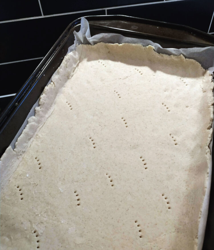 Uncooked pizza base in oven dish