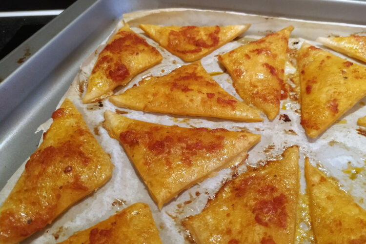 Baked puff pastry triangles with red pesto