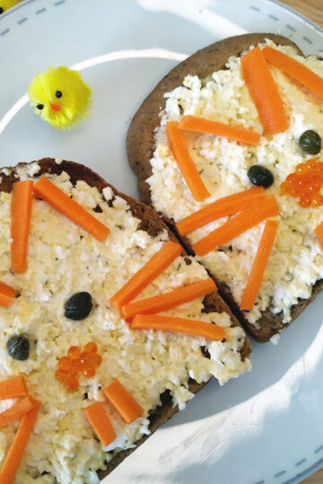 Two open sandwiches with decorations and egg mayo